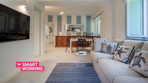 A modern kitchen with a dining area, a sofa with nautical-themed cushions, and a small round table. - Comfy and Quiet in Camogli by Wonderful Italy (Camogli)