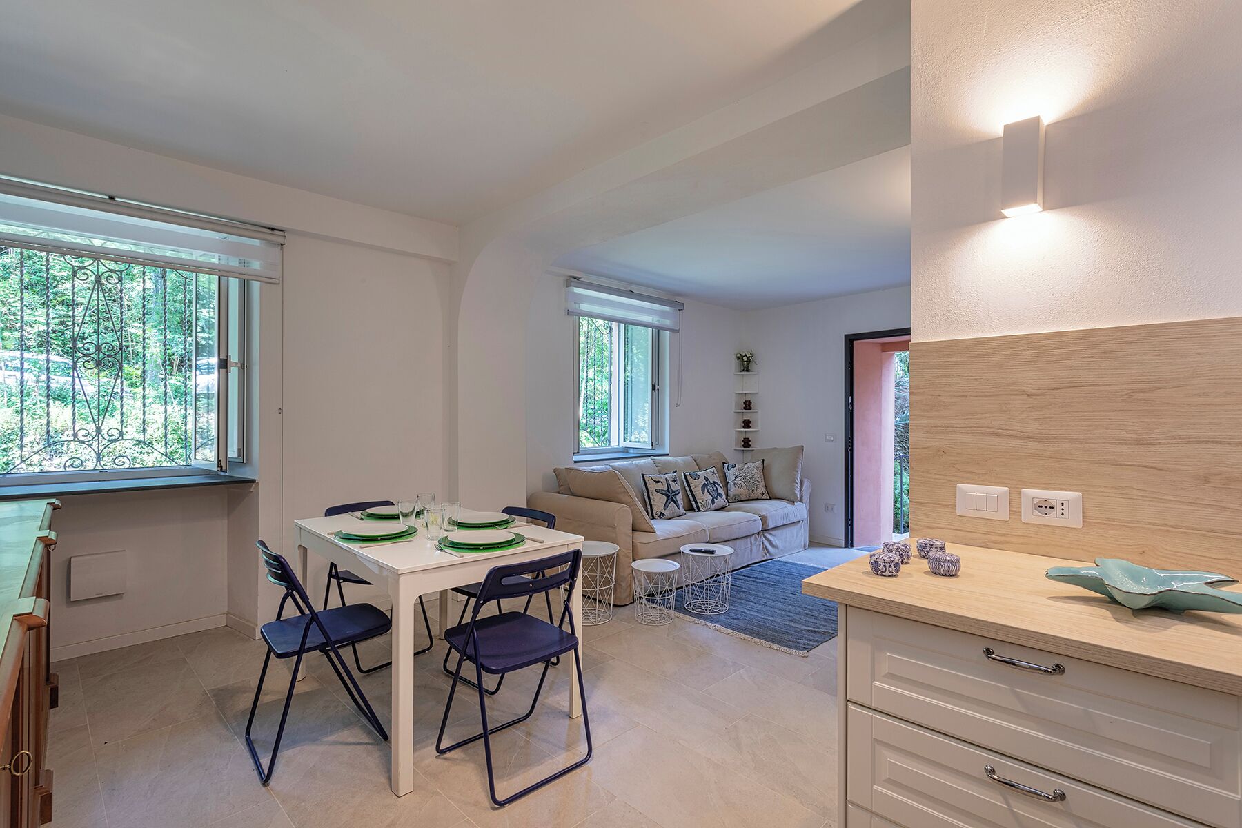 Un espace de vie compact comprenant un coin repas, un canapé et un comptoir de cuisine.