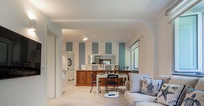 A modern kitchen with a dining area, a sofa with nautical-themed cushions, and a small round table. - Comfy and Quiet in Camogli by Wonderful Italy (Camogli)
