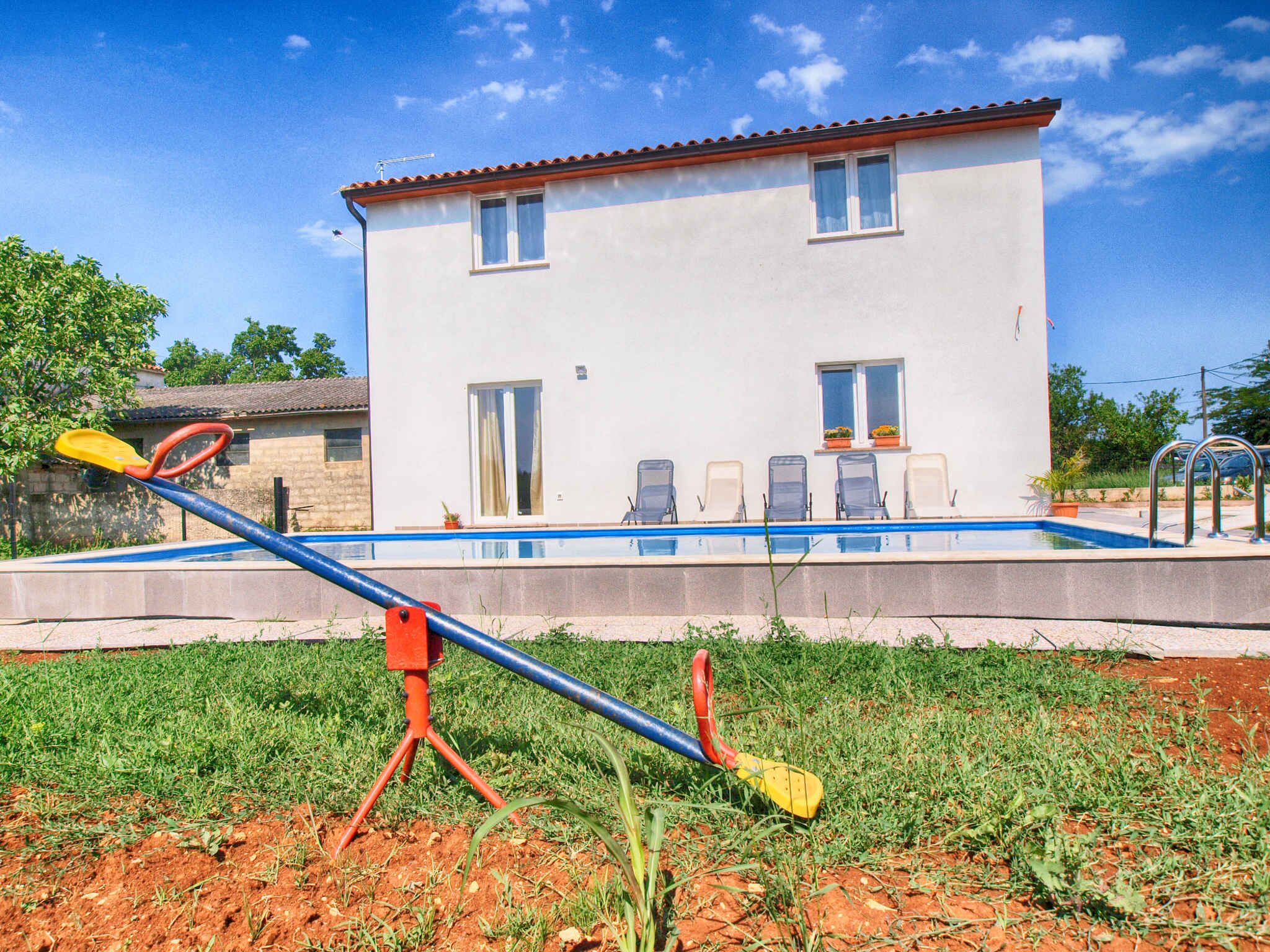 Un bâtiment à deux étages avec une piscine devant.