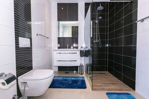 Un bagno moderno con il water, un lavandino e una doccia.