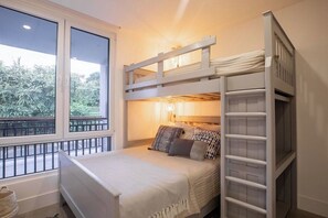 Habitació amb literes, una taula de nit i una làmpada.