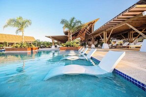 Un espace piscine avec des chaises longues et une structure en bois.