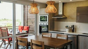 Una cocina moderna con comedor, ventanas amplias y vistas al exterior.