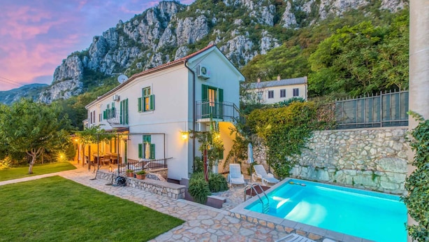 A two-story house with a swimming pool, stone patio, and a view of mountains. - Villa with pool for 8 people (Grižane)