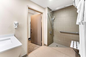 Een badkamer met een douche, een wastafel en een handdoekhouder.