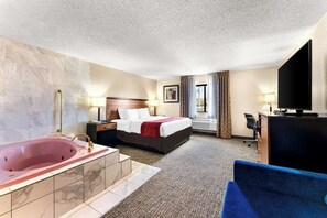 A hotel room with a large bed, a separate bathroom with a bathtub, a desk with a computer, and a window with curtains. - Surestay Plus by Best Western Reading North (Reading)