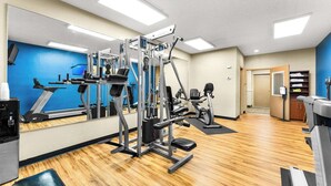 Une salle de sport équipée de machines de cardio, de matériel de musculation et dotée d’un mur recouvert de miroirs.