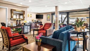Un hall d’hôtel doté d’un espace salon, d’un coin café, d’un téléviseur et offrant une vue sur l’extérieur.