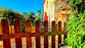 A wooden fence with a stone building in the background. - Chambre d'hôte Opale - Refinement, serenity and well-being guaranteed (Puy-l'Évêque)