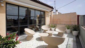 Una terrazza panoramica con mobili moderni, ampie finestre e piante in vaso.