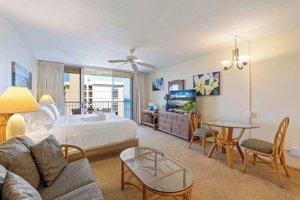 Ein Hotelzimmer mit Bett, Schreibtisch, Esstisch und Balkon.