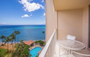 A balcony with a view of the ocean and a swimming pool.