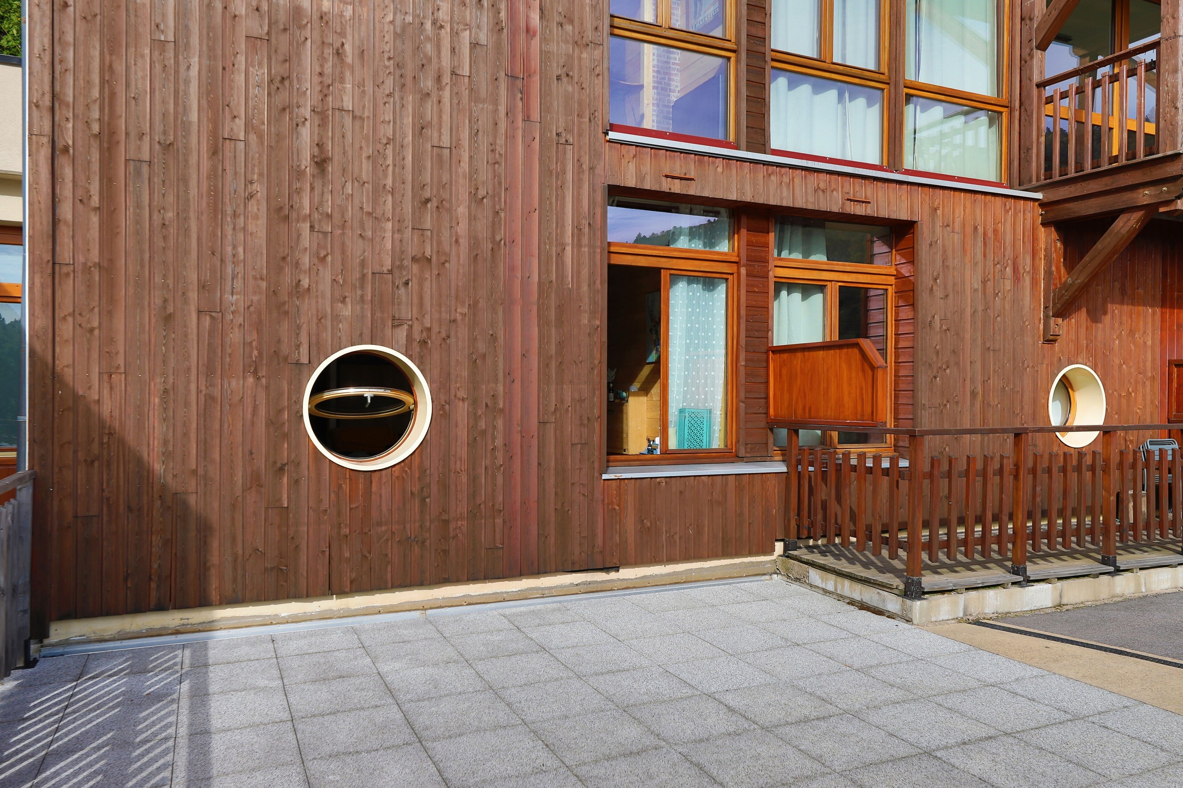 Un edificio moderno con fachada de madera, ventanas amplias y un balcón.