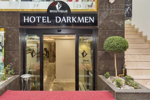 L'ingresso dell'Hotel Darkmen, con una reception e una scala che conduce ai piani superiori.