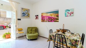 Un coin repas avec une table dressée pour deux personnes, une chaise et une plante en pot.