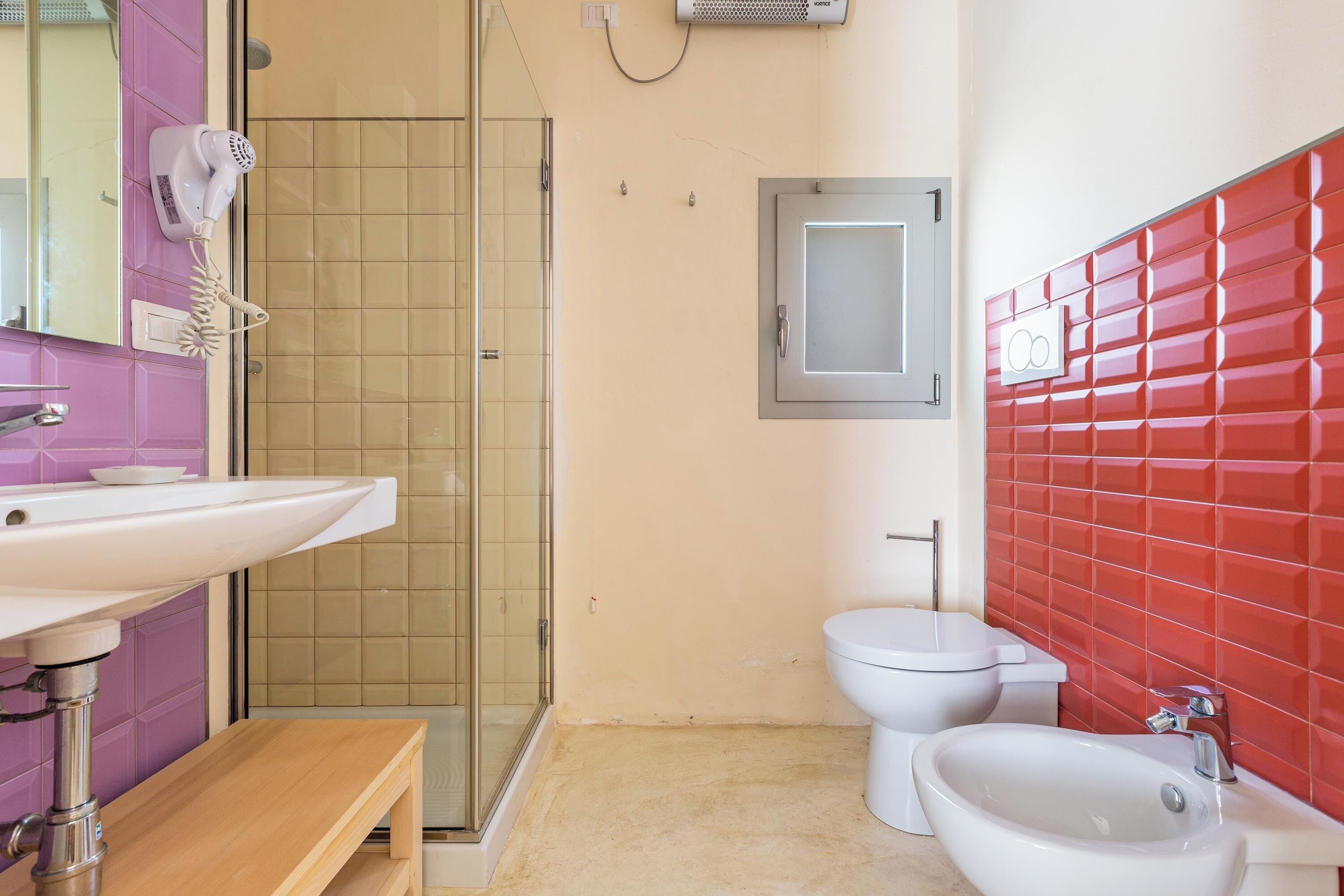 Een badkamer met douche, toilet, bidet en wastafel.