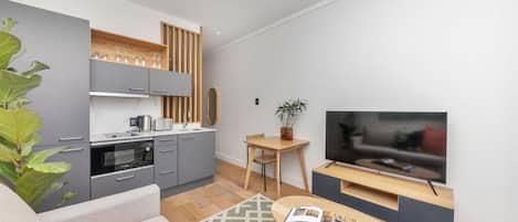 A modern living space with a kitchen, dining area, and a TV.