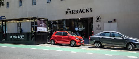 A building with a storefront labeled 'The Barracks' and a sign for '50 BREE Light House.'