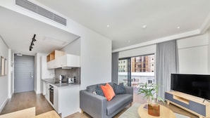 A modern apartment with a kitchen, living area, and balcony. - The Barracks (Cape Town)