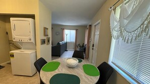 Un comedor con una mesa redonda, sillas y un cuenco decorativo en el centro.