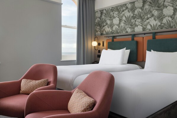 A hotel room with two beds, a large window, and a floral wallpaper. - Doubletree By Hilton Brighton Metropole (Brighton)