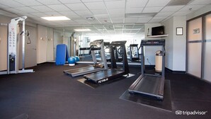 Un gimnasio con cintas de correr, pelotas de ejercicio y máquinas de pesas.