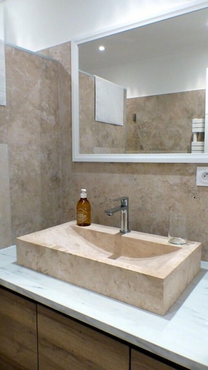 Bathroom features a rectangular sink, large mirror, and a towel hanging on the wall.