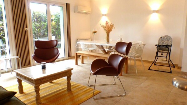 Relax in this serene living space with a dining area, large window, and beautiful views of the outdoors.