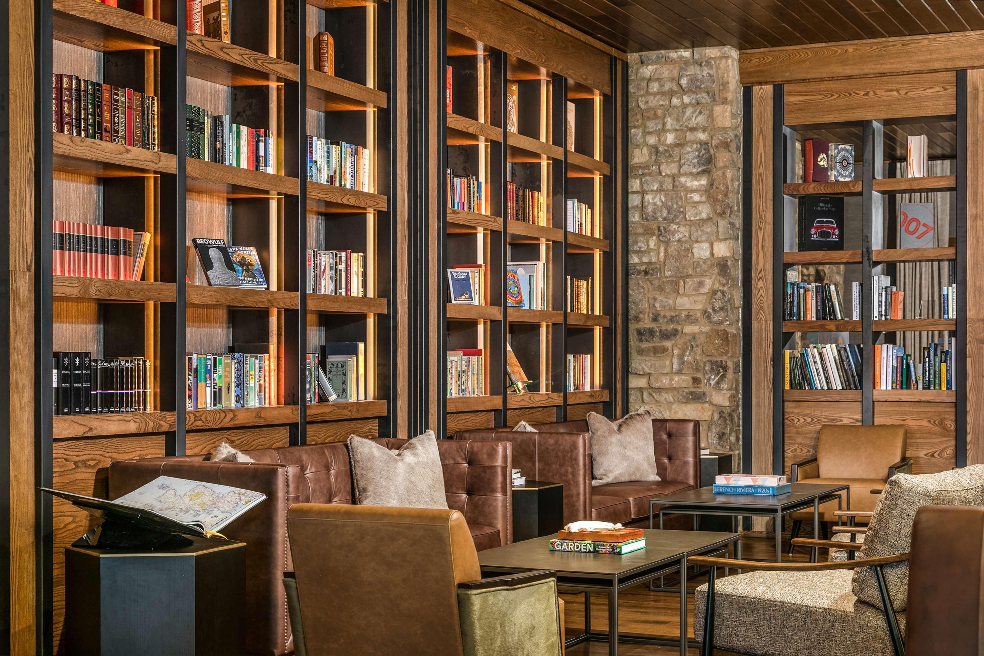 A library with leather seating and bookshelves filled with books.