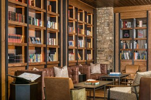 A library with leather seating and bookshelves filled with books.