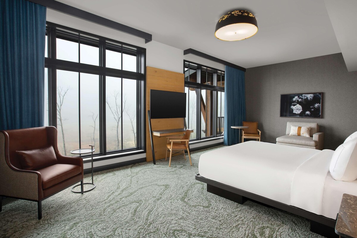 Une chambre d’hôtel avec un grand lit, un bureau, une chaise et un canapé.