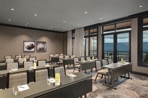A hotel conference room with tables, chairs, and a large window offering a view. - Cloudland Mclemore Resort Lookout Mountain Curio (Rising Fawn)