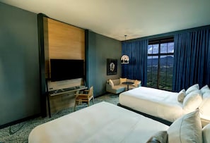 A hotel room with two beds, a TV, a desk, a chair, a small table, and a view of the outdoors. - Cloudland Mclemore Resort Lookout Mountain Curio (Rising Fawn)