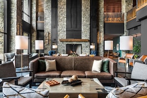 Una zona relax moderna con camino in pietra, divani in pelle e lampade dal design contemporaneo.