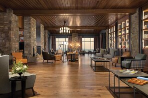 A spacious lobby with wooden flooring, modern furniture, and large windows offering views. - Cloudland Mclemore Resort Lookout Mountain Curio (Rising Fawn)