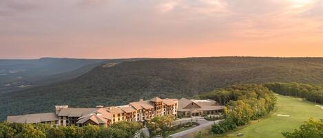 A large hotel with multiple buildings, surrounded by lush greenery and a golf course.