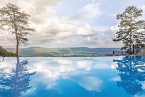 A clear view of a swimming pool with reflections of trees and mountains. - Cloudland Mclemore Resort Lookout Mountain Curio (Rising Fawn)