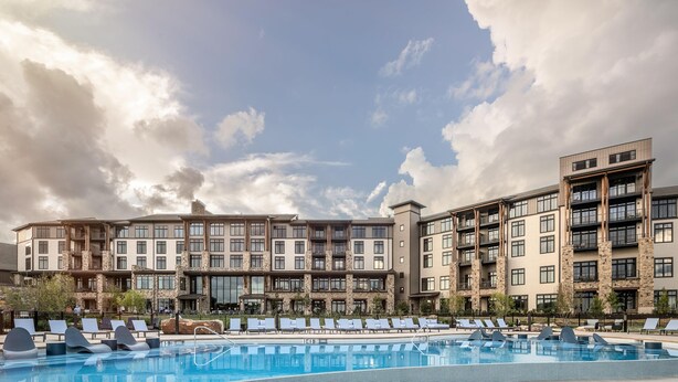 Un hôtel doté d’une piscine, de nombreux balcons et d’une architecture moderne.