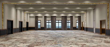 A spacious conference room with a patterned carpet, large windows with curtains, and a view of the outdoors.