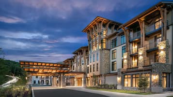 A multi-story hotel with a covered entrance, stone facade, and multiple balconies.