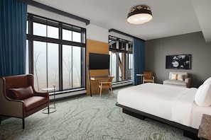 Een hotelkamer met een groot bed, een bureau, een stoel en een bank.