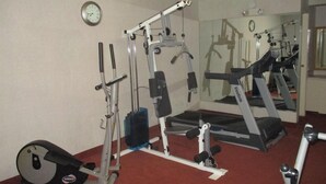 A gym with various exercise equipment including a treadmill, weight machines, and a stationary bike. - Travelodge by Wyndham Suffolk (Suffolk)