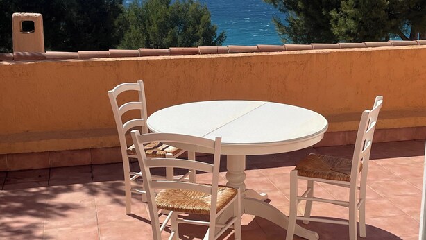 A round table with four chairs on a terrace with a view of the sea and hills. - T2 sea view, very quiet. (Saint-Cyr-sur-Mer)