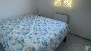 A small, sparsely furnished room with a single bed, a window with a view of trees, and a plain white wall. - T2 sea view, very quiet. (Saint-Cyr-sur-Mer)