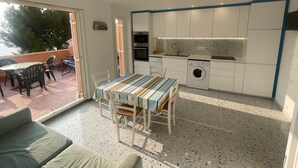 A compact living space with a dining area, kitchenette, and a view of the outdoors. - T2 sea view, very quiet. (Saint-Cyr-sur-Mer)