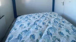 A bedroom with a bed, an air conditioning unit, and a door. - T2 sea view, very quiet. (Saint-Cyr-sur-Mer)
