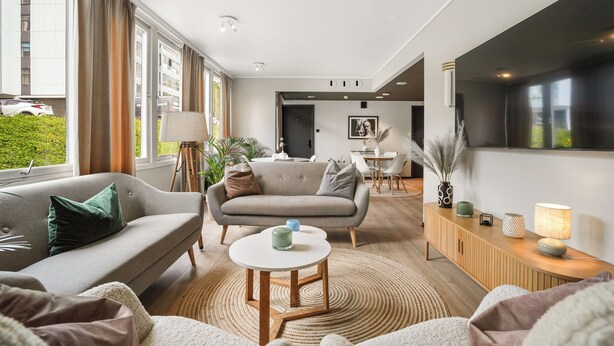 A modern living room with a sofa, a coffee table, and a TV. - A-11 (Ålesund)