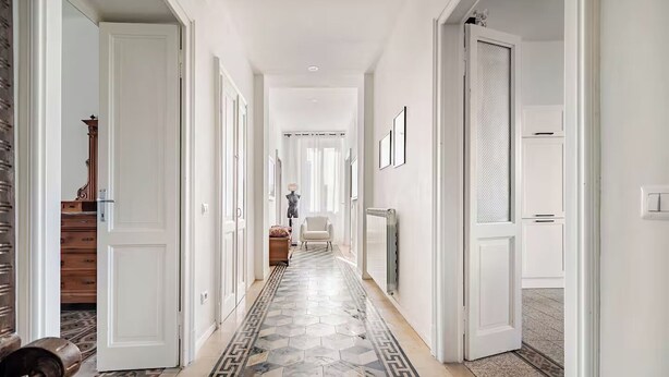 A hallway with patterned tiles, white doors, and a radiator. - Former palace, picturesque apartment, lake view (Lombardia)