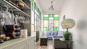 A cozy living area with a sofa, a small table, and a decorative lamp. There is a shelf with wine glasses and a small toy car. - Former palace, picturesque apartment, lake view (Lombardia)